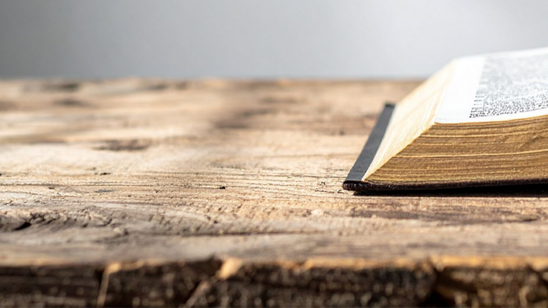 Open book resting on a wooden table, symbolising how ordinary life quietly shapes us before we choose.