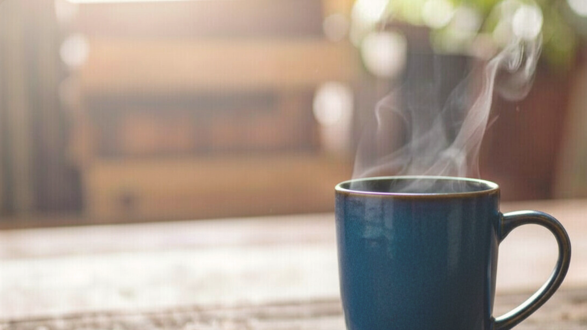 Woman reading beside morning coffee and books on a quiet table, early sunlight through a curtain — representing searching for a life one can truly hold.