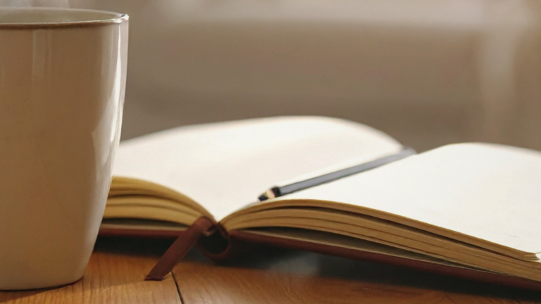 Open book with steam rising in soft morning light, symbolising reflection and understanding